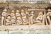 Khajuraho - Lakshmana temple the frieze of the temple base, figure of authority with acolytes 